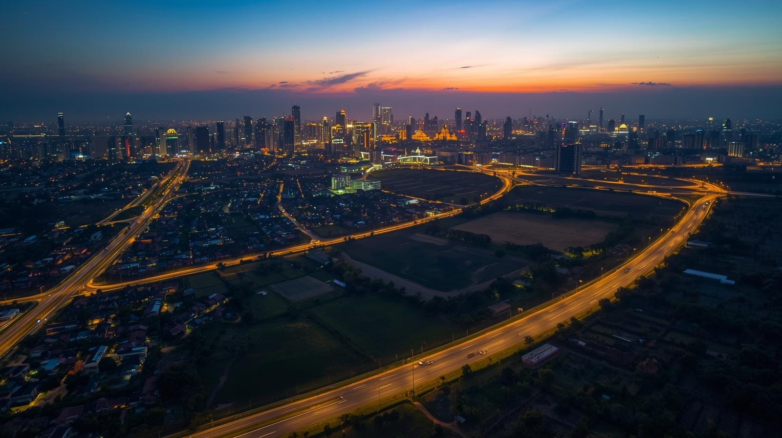 Bangkok skyline seen from Nakhon Pathom outskirts at sunset.